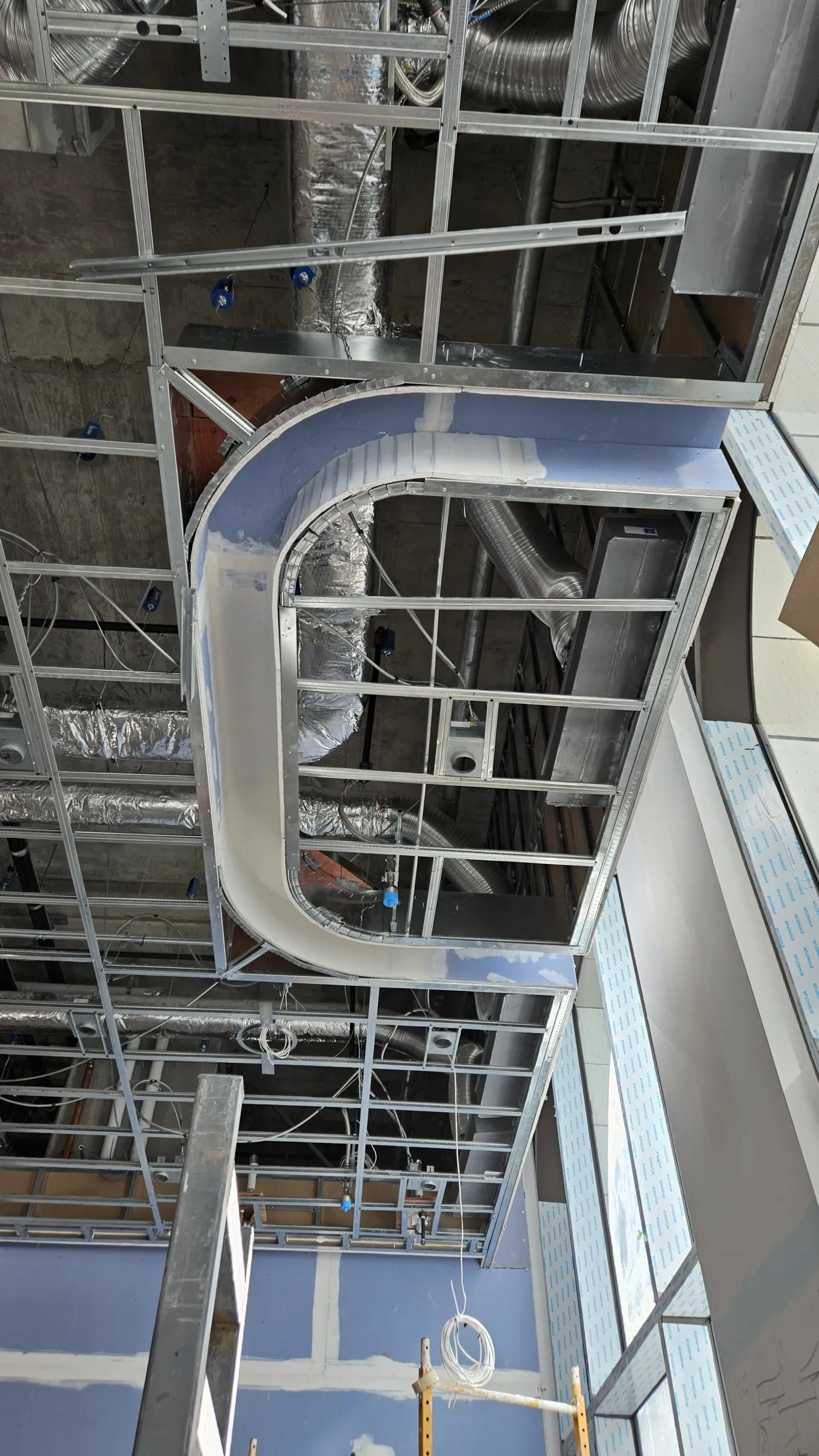 Steel framing for a bulkhead with a curved corner below open ductwork