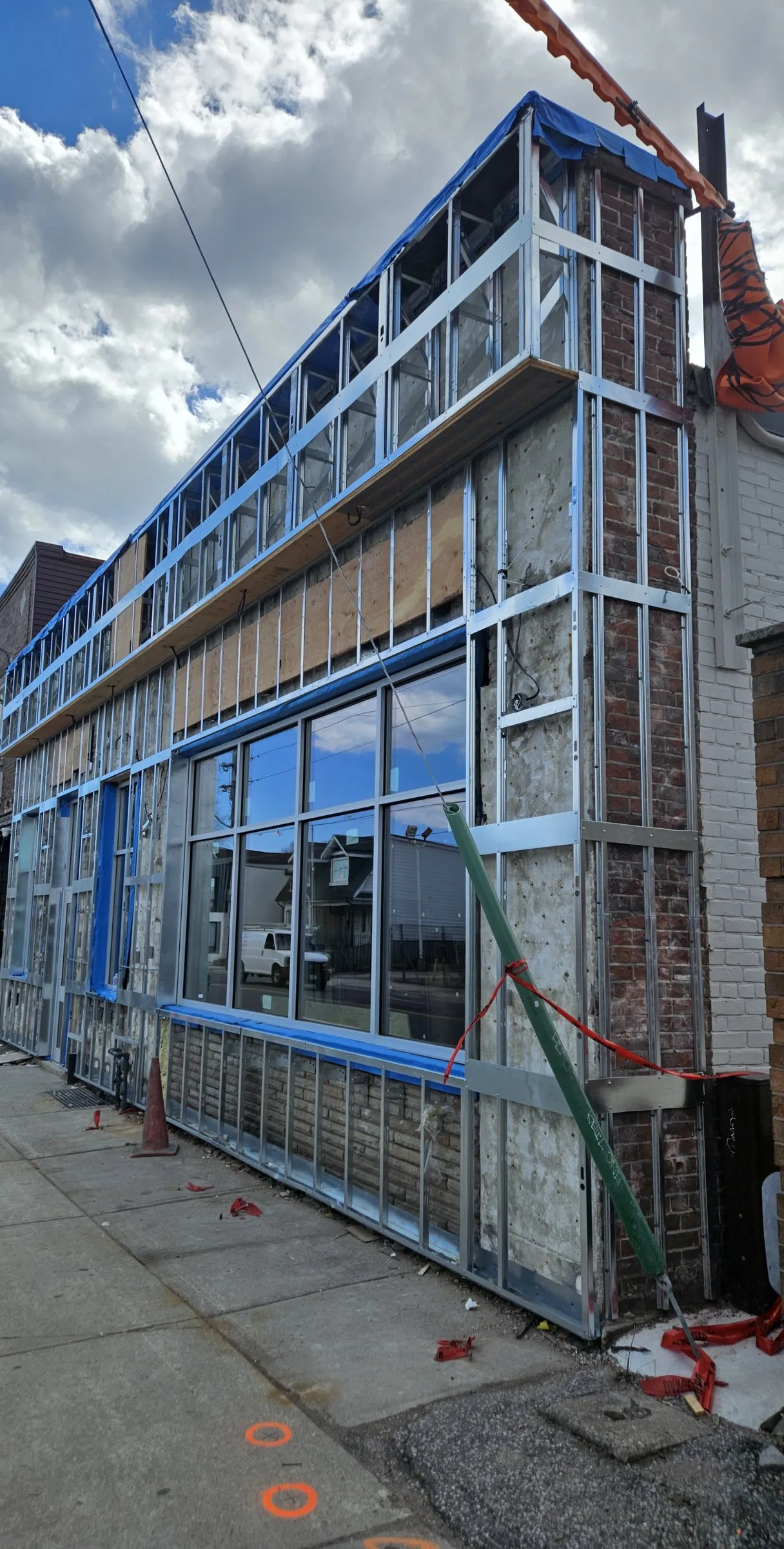 Two-storey storefront with new steel stud framing over the old brick façade