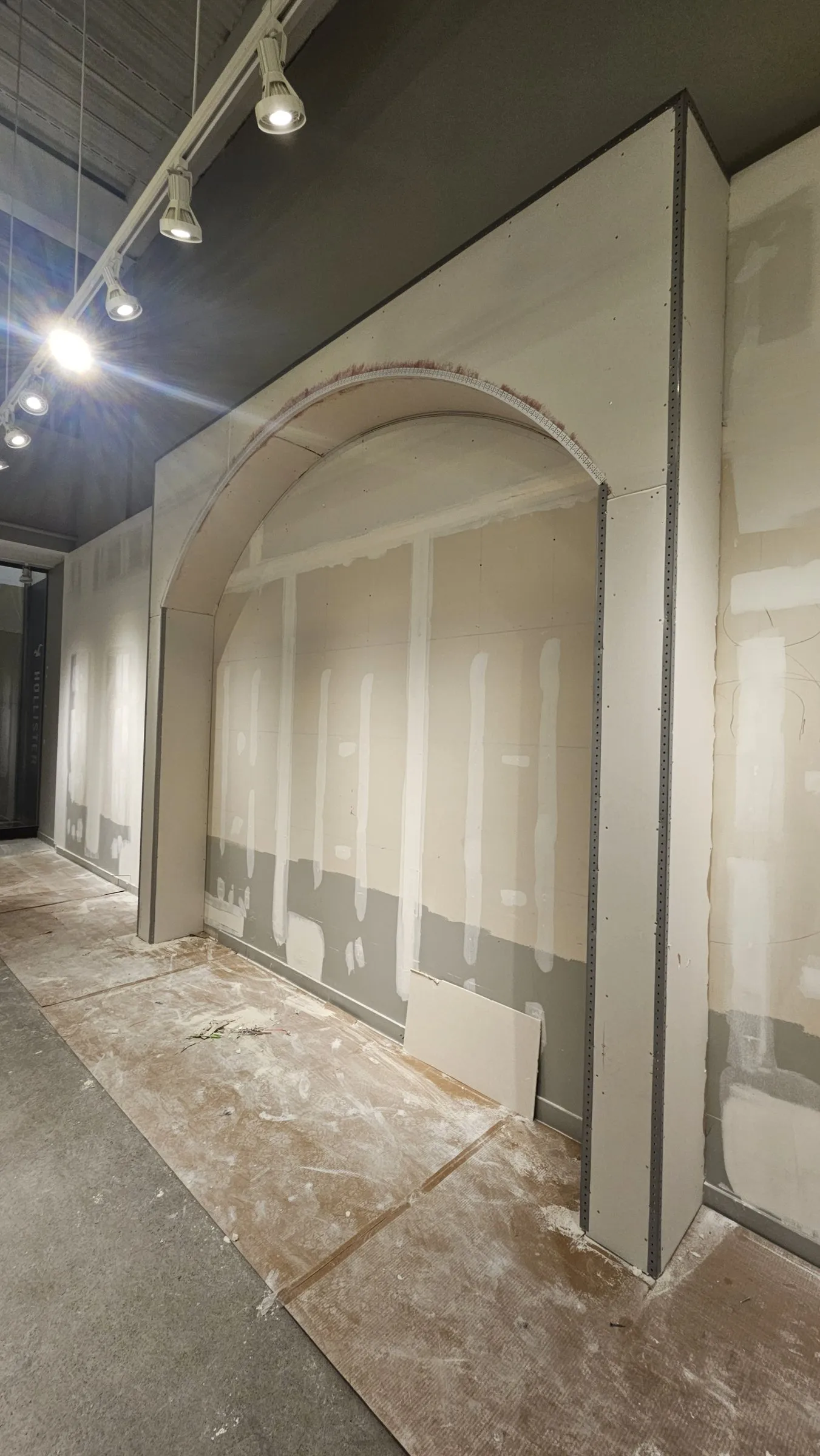 Large drywall arch with taped joints in a retail interior