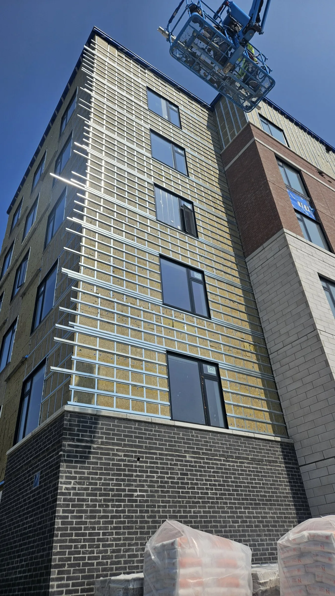 Steel cladding girts over mineral wool at a building corner