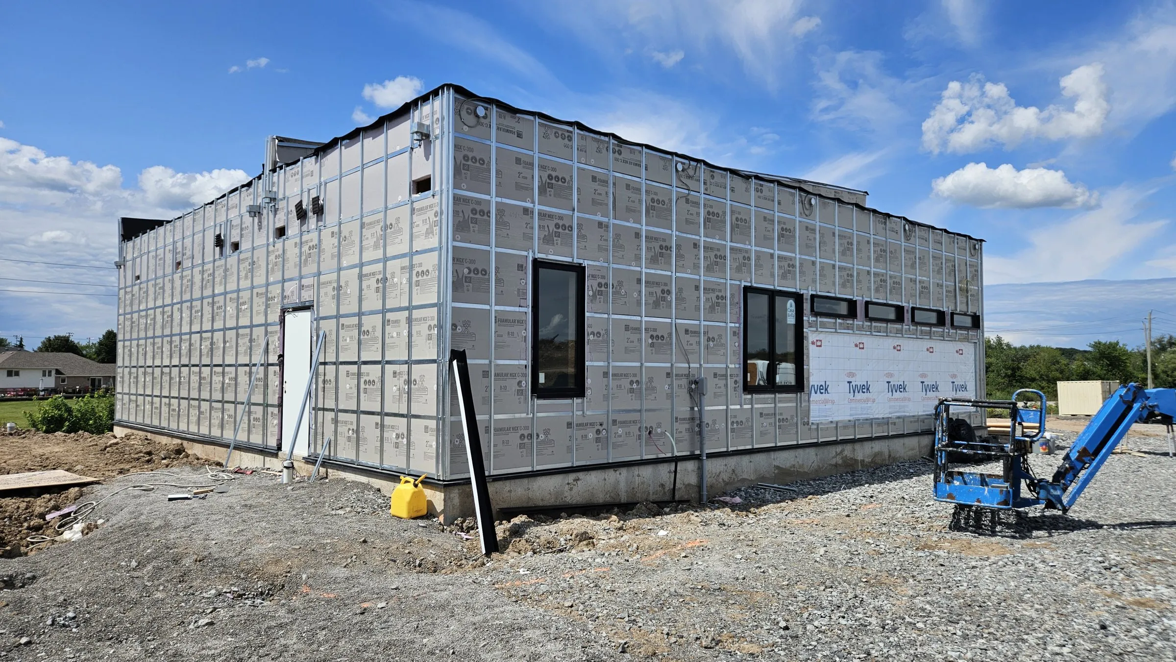 Single-storey building wrapped in rigid insulation with a steel girt grid