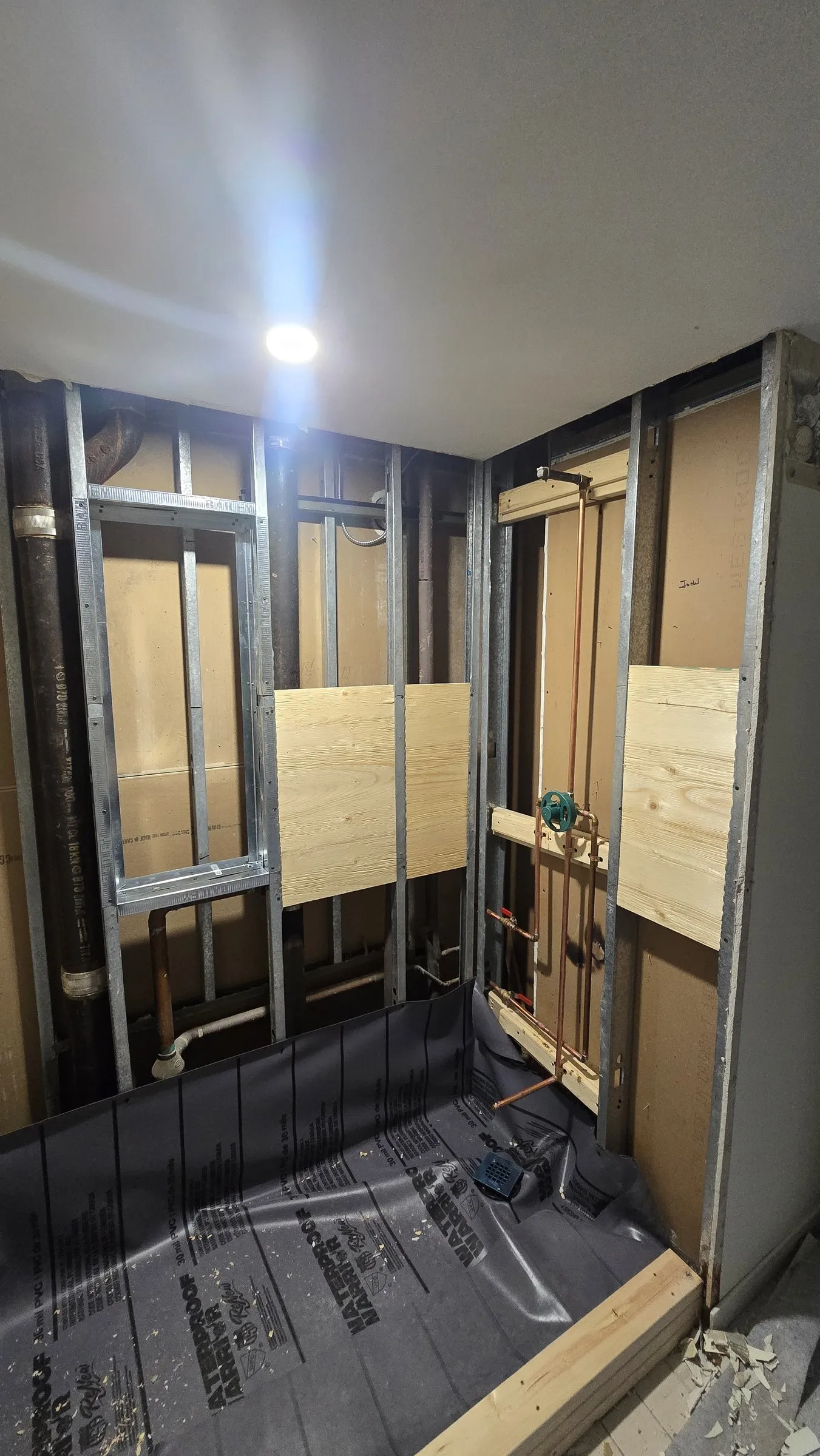 Steel stud wet wall with wood blocking around plumbing lines