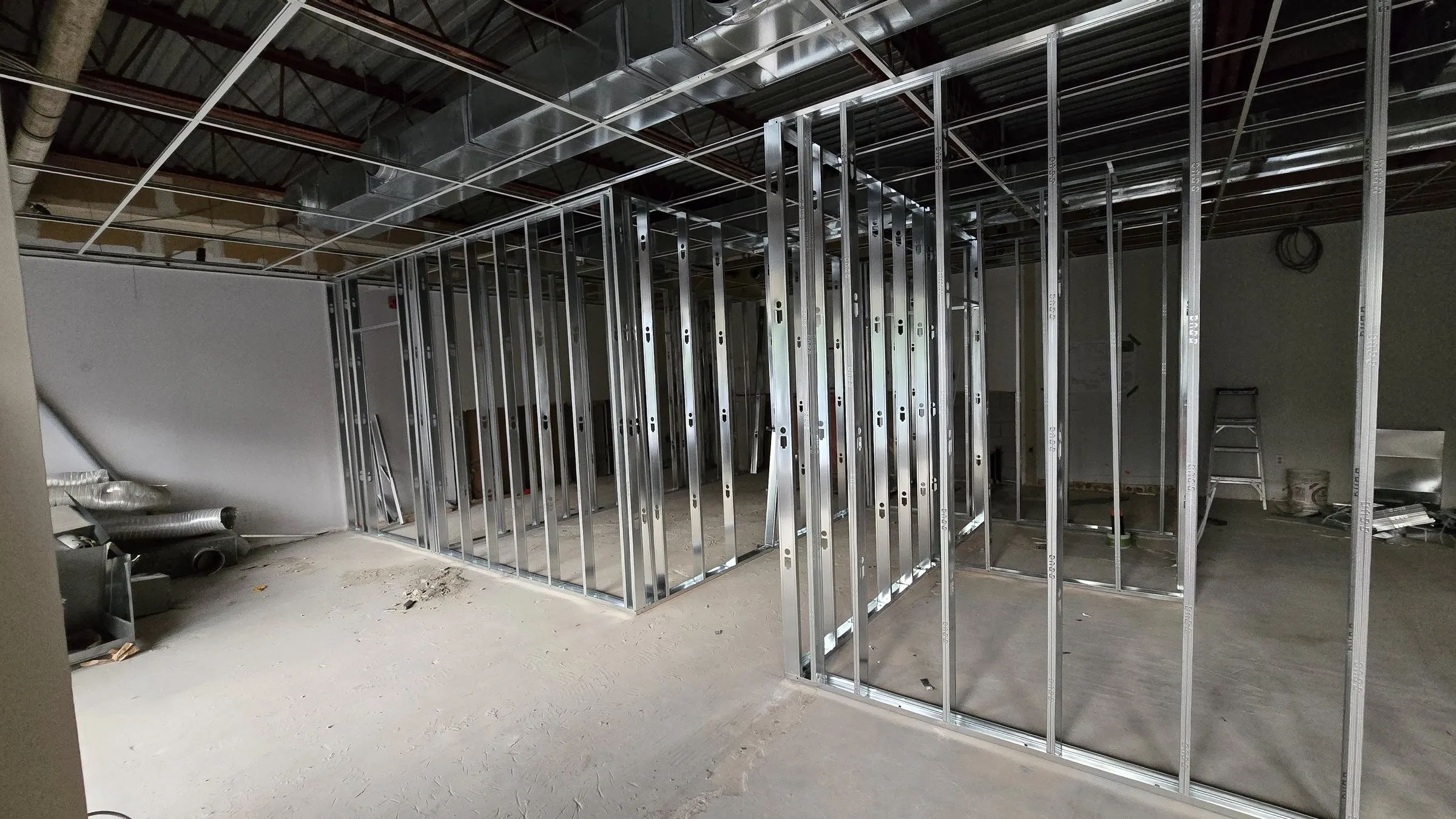 Steel stud office partitions with the T-bar ceiling grid hung above them